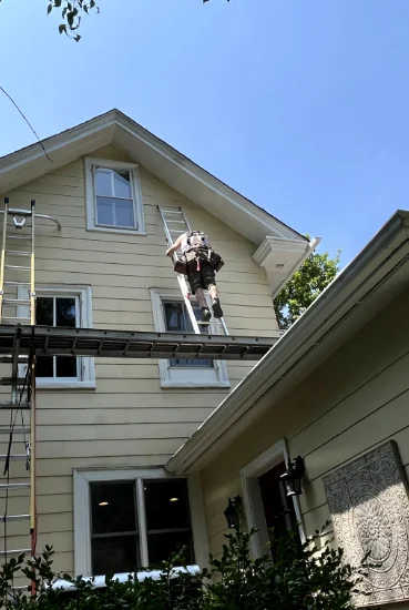 A worker assessing the siding of a residential home