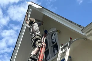an employee installing custom-cut gutters on a residential home in Newtown Square, PA